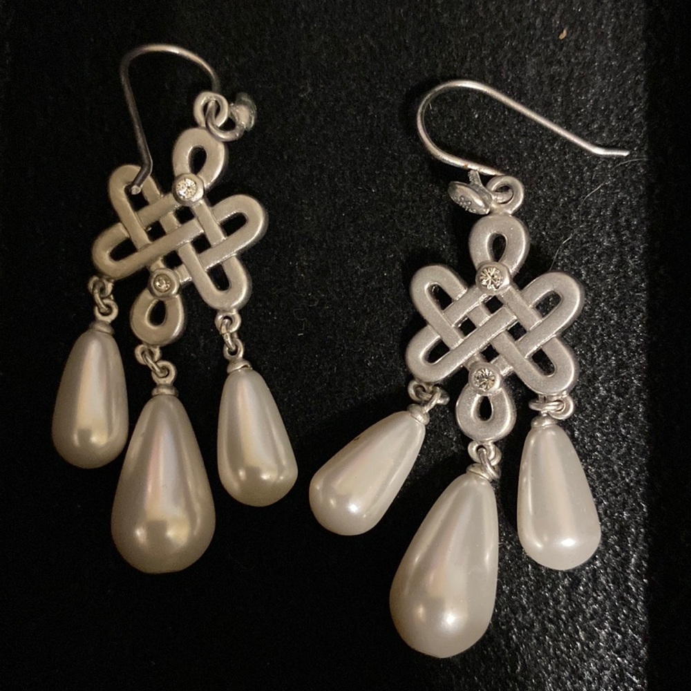 Signature love knot white pearl drop earrings. silver finish.